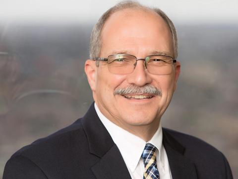 John Lefante, PhD, Chair of Biostatistics John Lefante, smiling, wearing a suit, next to a window